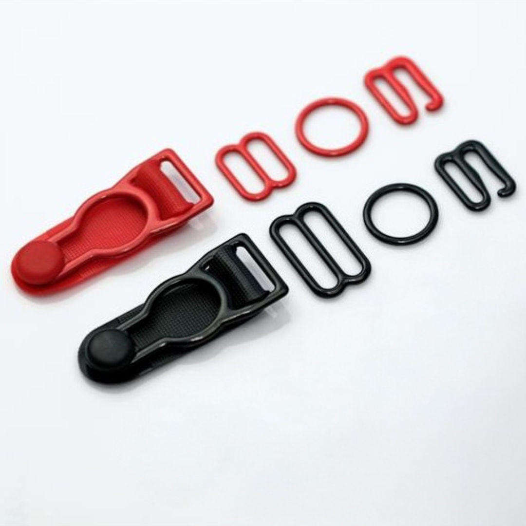 Red and black plastic buckles and matching rings arranged on a white background.