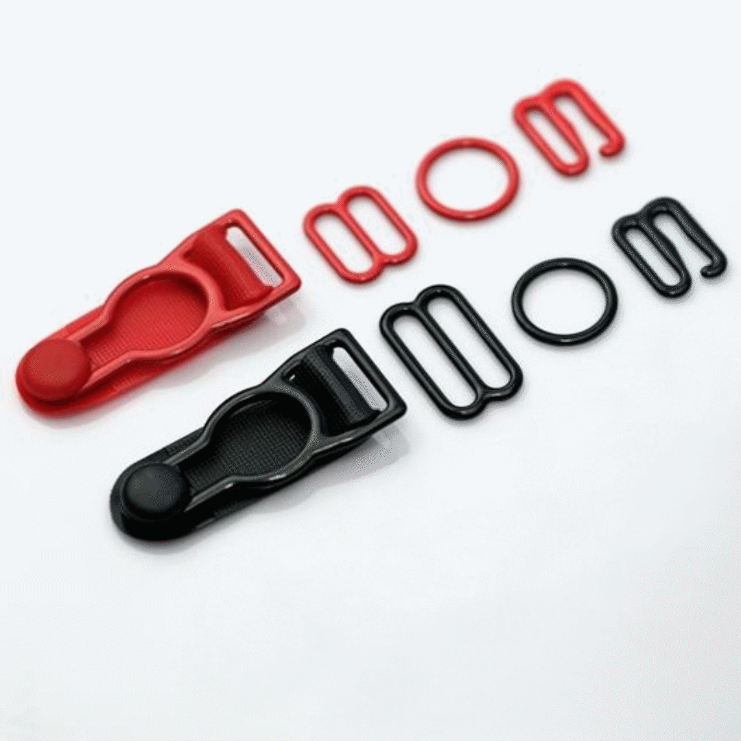 Red and black plastic buckles and matching rings arranged on a white background.