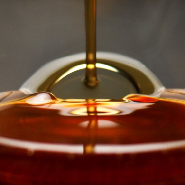 Leicht rötliches Algenöl, das in ein Glas ließt.