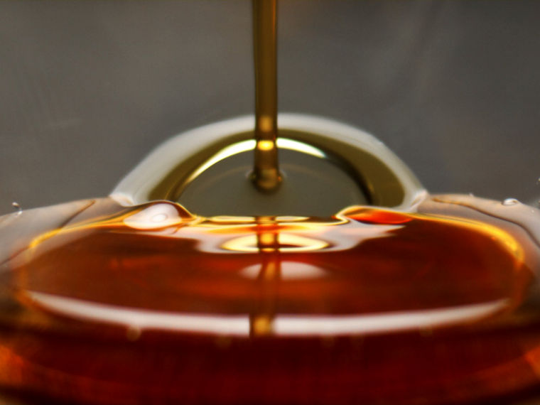 Slightly reddish algae oil being poured into a glass.