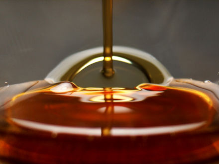 Slightly reddish algae oil being poured into a glass.