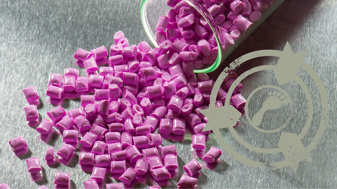 Small pink plastic granules poured from a glass container onto a metallic surface, representing raw polyamide material created with a focus on circular and sustainable production