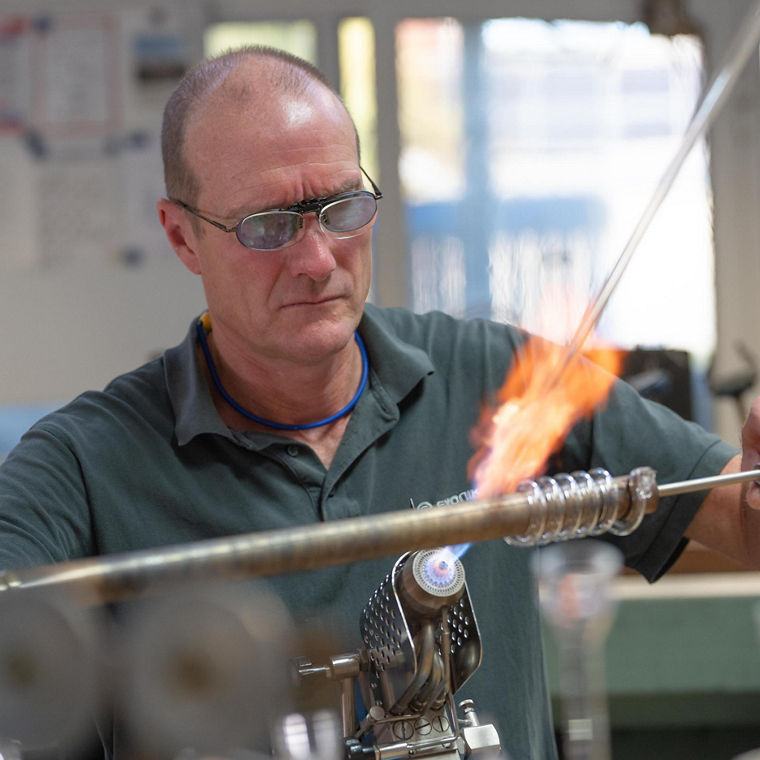 Udo Musholt dreht langsam erhitztes Glas zu einer Spirale.