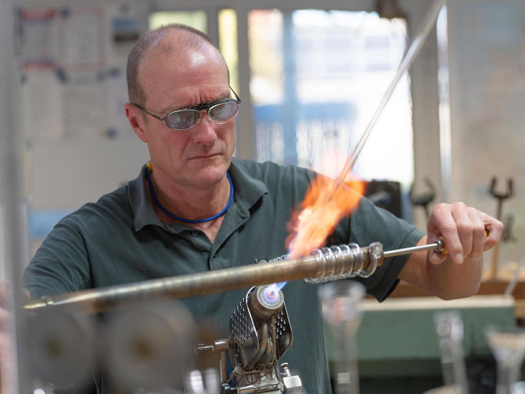 Udo Musholt dreht langsam erhitztes Glas zu einer Spirale.