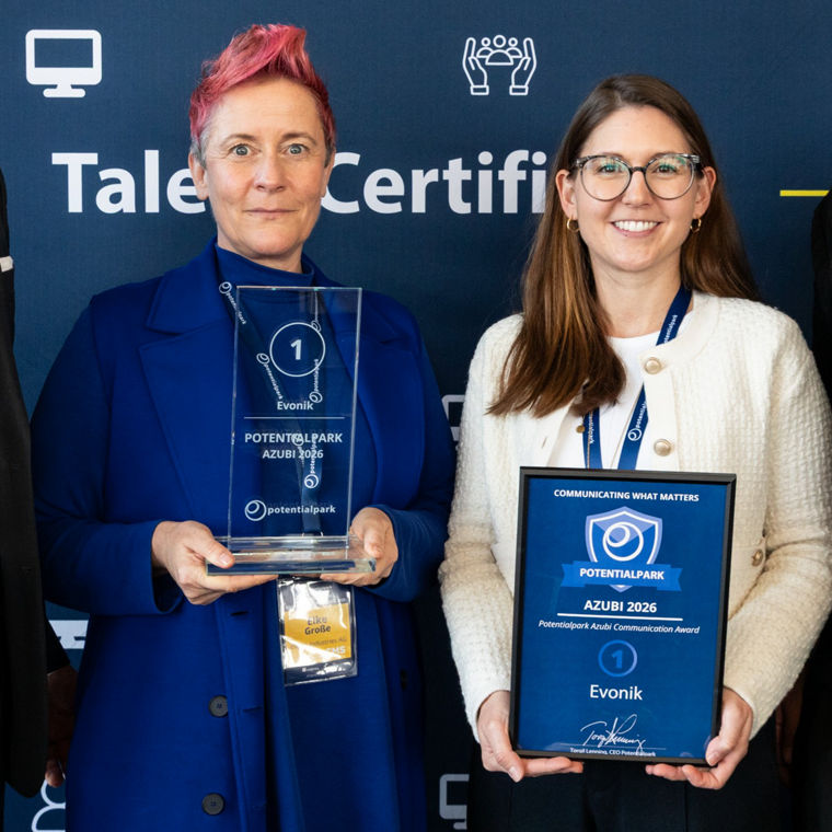 Vier Personen stehen vor einem Banner von Potentialpark und halten Auszeichnungen in den Händen.