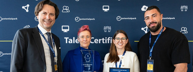 Vier Personen stehen vor einem Banner von Potentialpark und halten Auszeichnungen in den Händen.