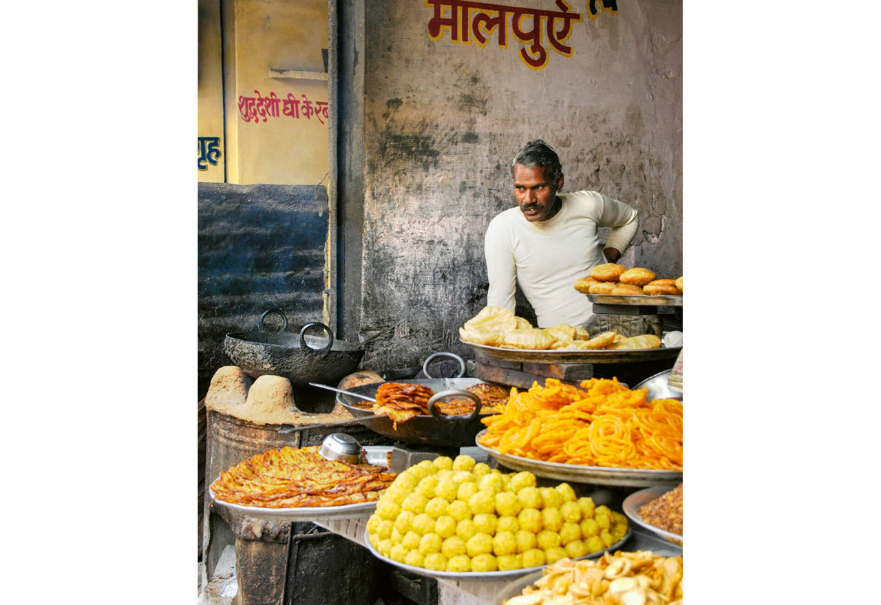 A street vendor sells baked goods by the roadside.