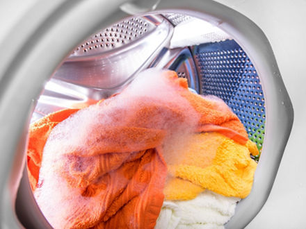 A washing machine drum with colored laundry.