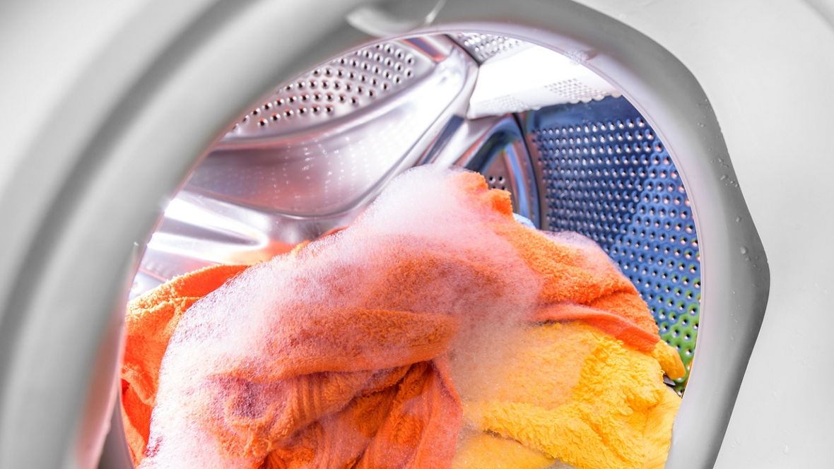 A washing machine drum with colored laundry.