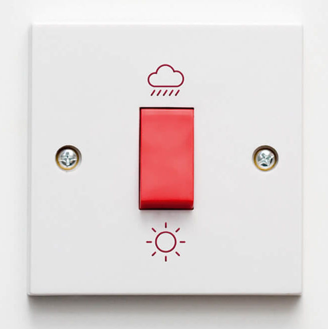 Ein Lichtschalter, der anstatt An und Aus eine Sonne und eine Wolke als Symbol hat.