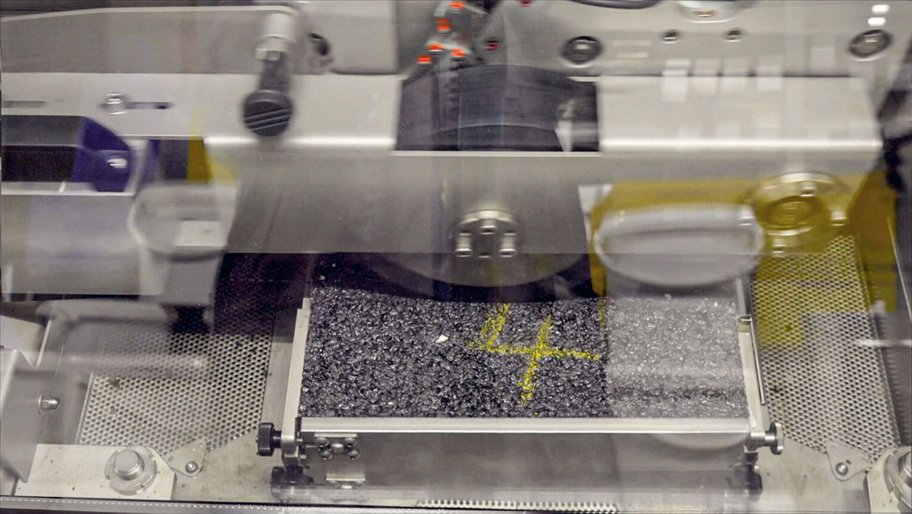 Ein Stück Straßenaspahlt in einer Prüfkammer.