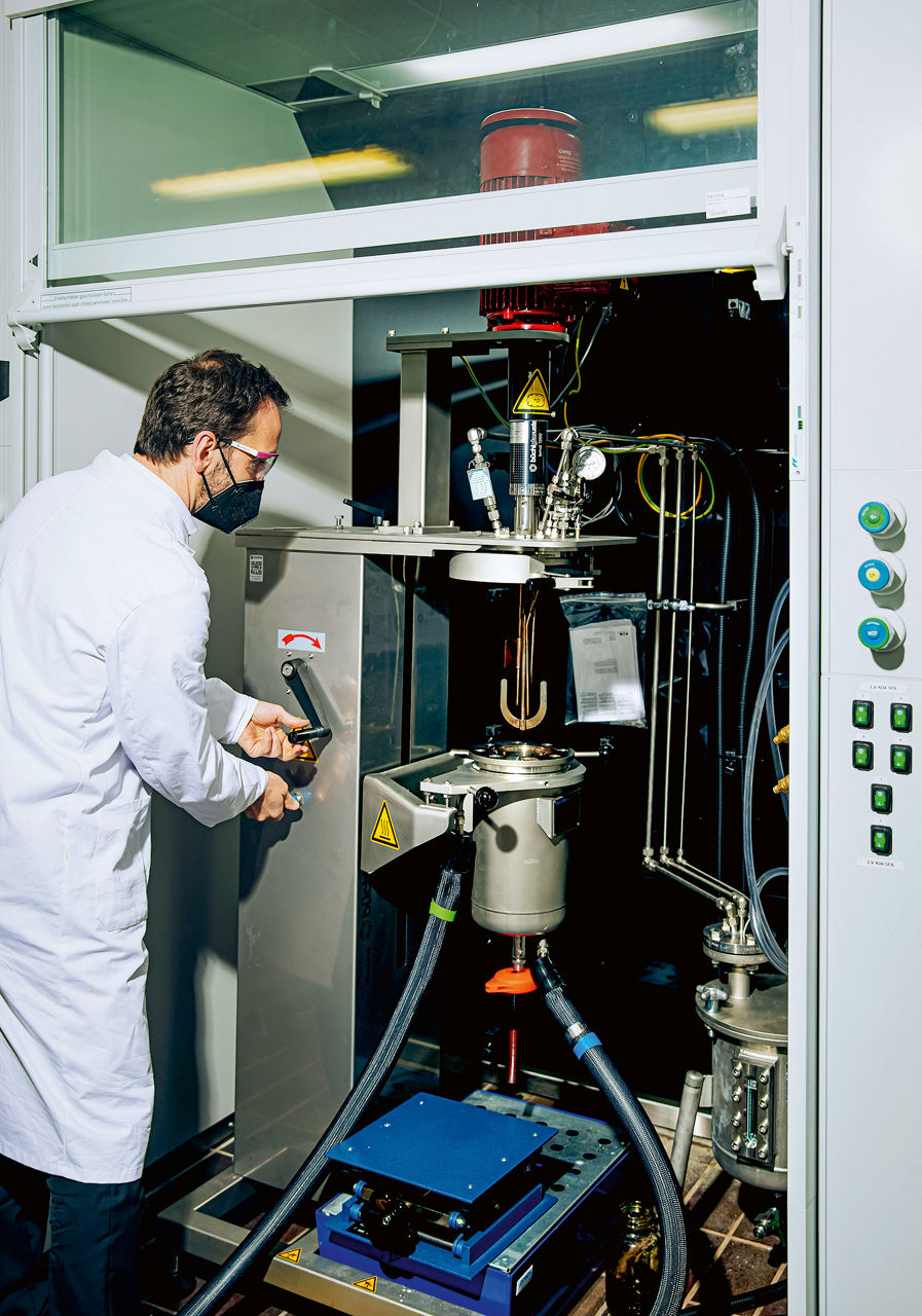 Michael Ferenz steht an einem Schrank und dreht eine graue Kurbel.