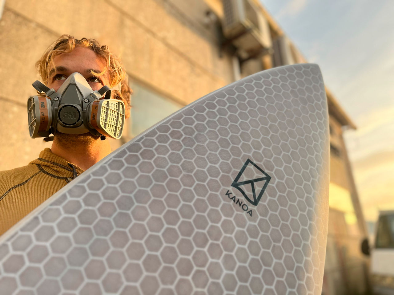 Thilo von Osterhausen wears a respirator mask and carries a freshly painted board.