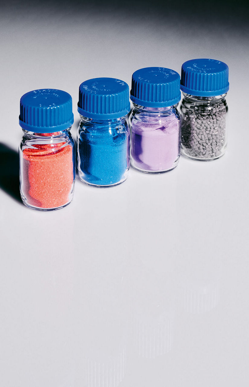 Vier Gläser mit unterschiedlich gefärbten Pulvern.