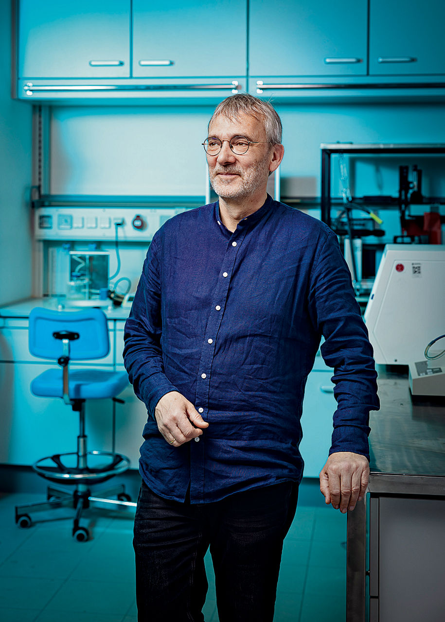 Joachim Venzmer lehnt in einem Labor an einem Tisch. Er trägt ein blaues Oberhemd und ene dunkle Hose.