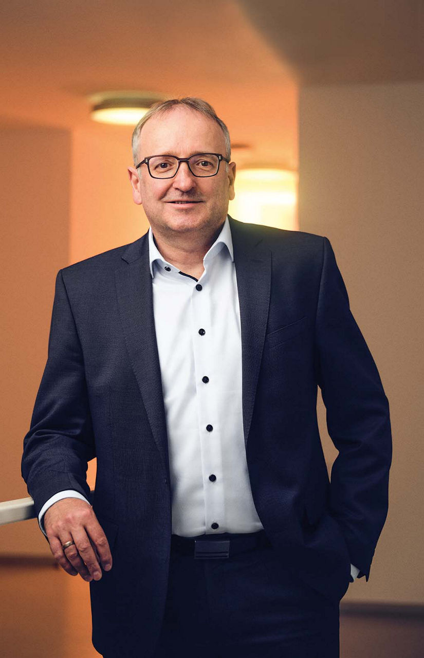 Stefan Pelzer leans against a railing and smiles into the camera.