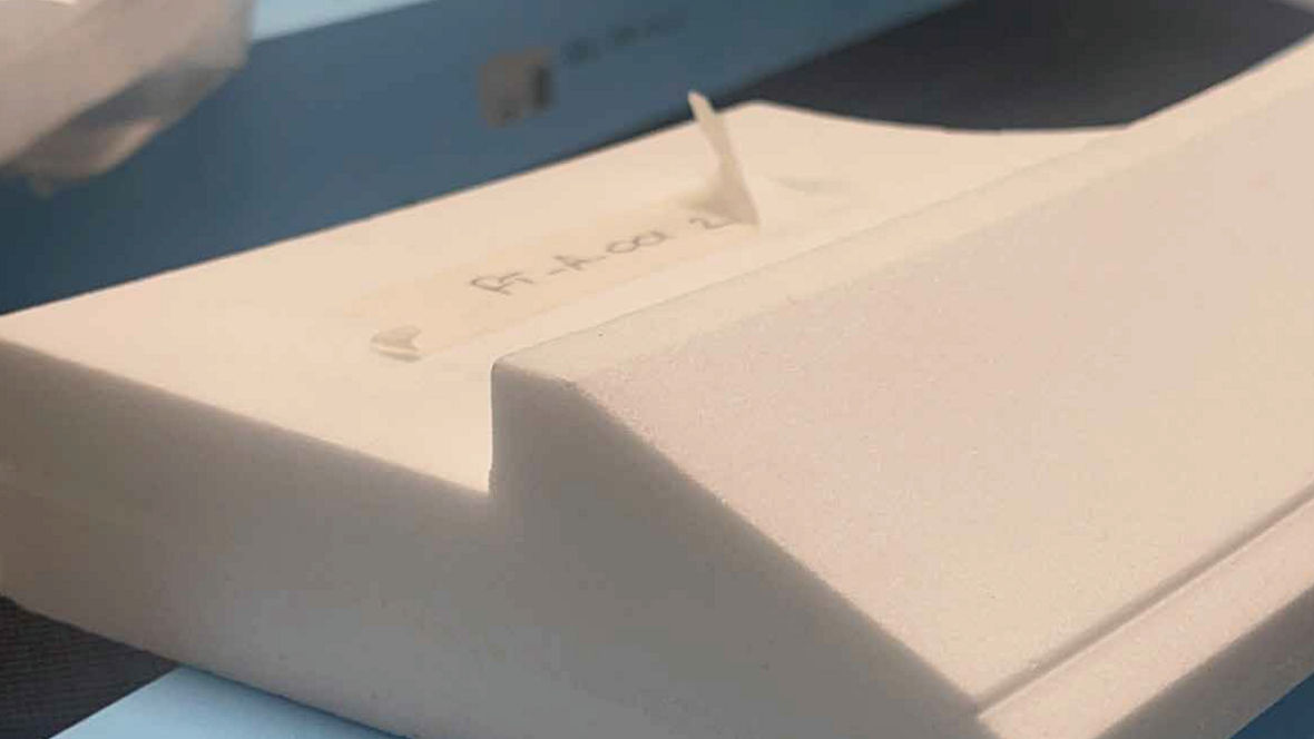 Close-up of a white foam block with a sloped cut and a small label on top.