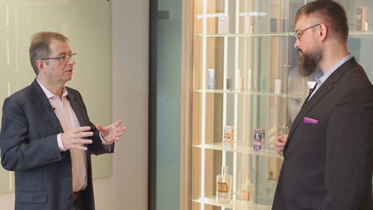 Zwei Männer unterhalten sich vor einem Glasregal