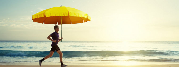 Man running on tropical beach at sunset