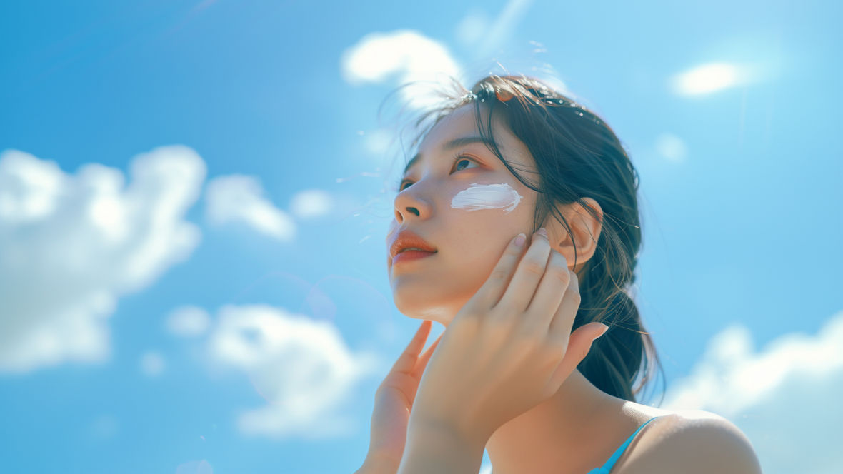 Junge asiatische Frau mit Creme auf den Wangen.