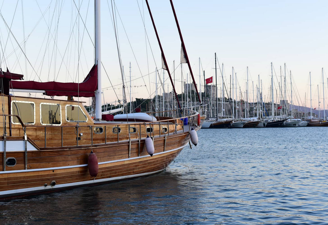A traditional wooden sailboat, a 'Gulet', anchored in the harbor