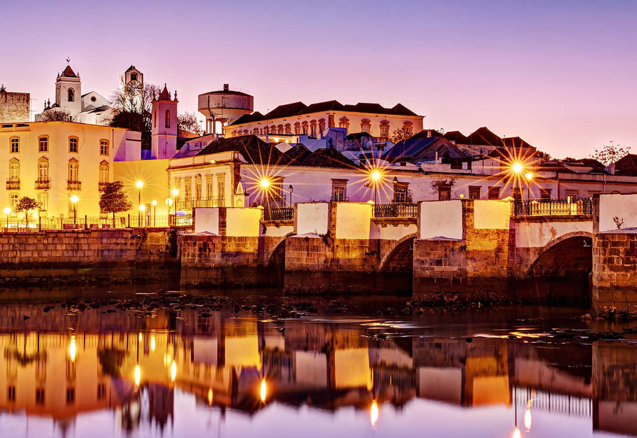 Die charmante Küstenstadt Tavira, schön beleuchtet in der Abenddämmerung