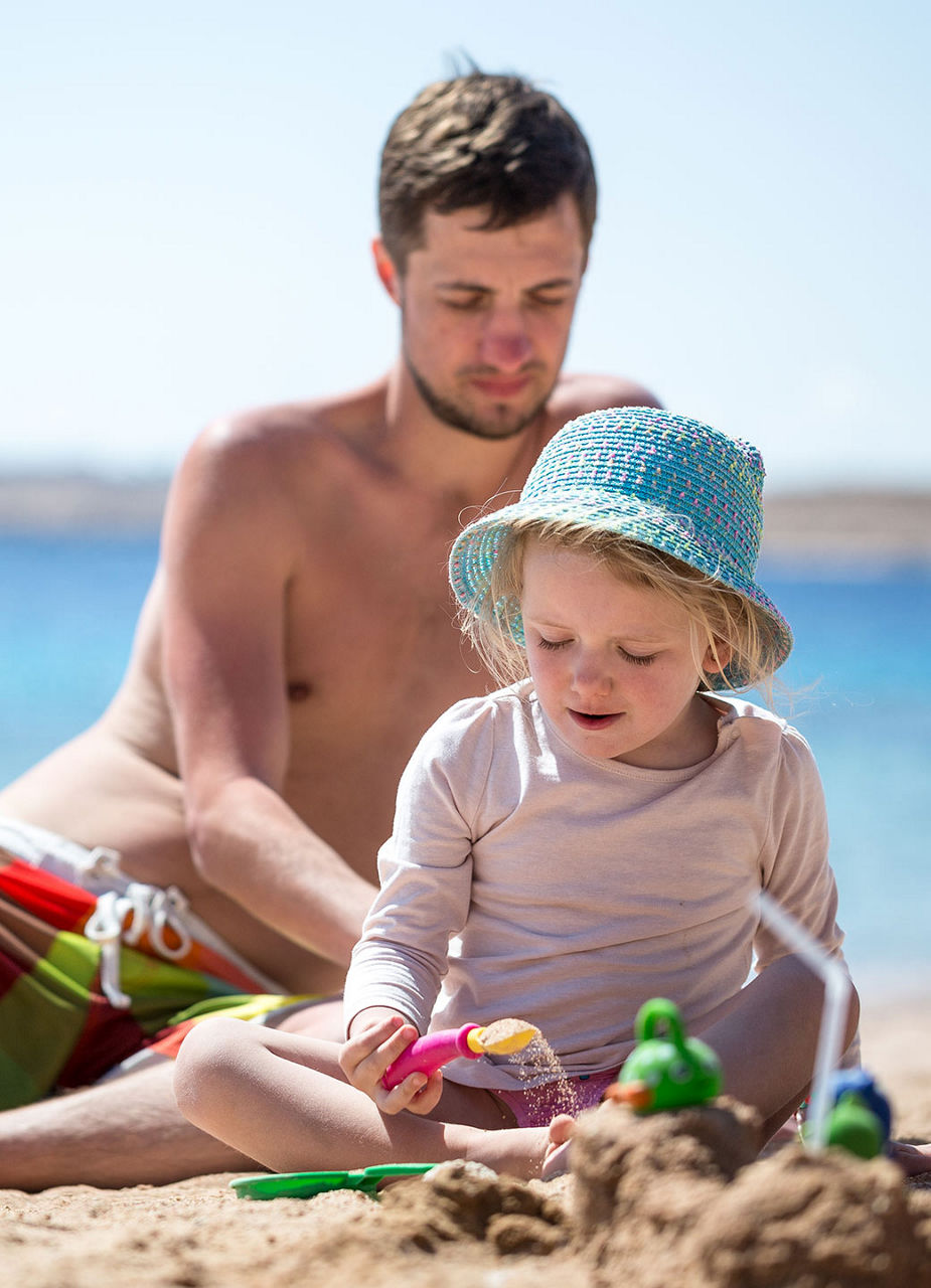 Père jouant dans le sable avec un enfant