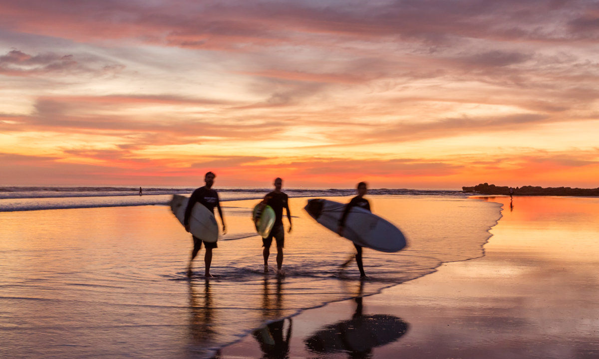 Three surfer in sunset