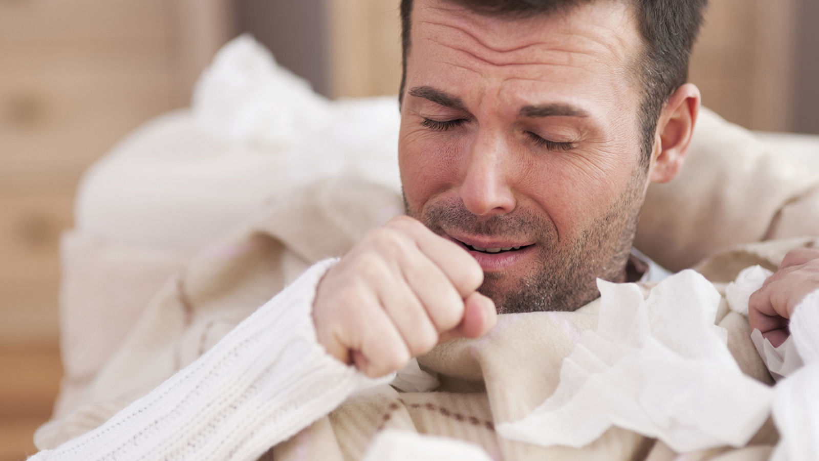 Sick man lying on sofa in living room