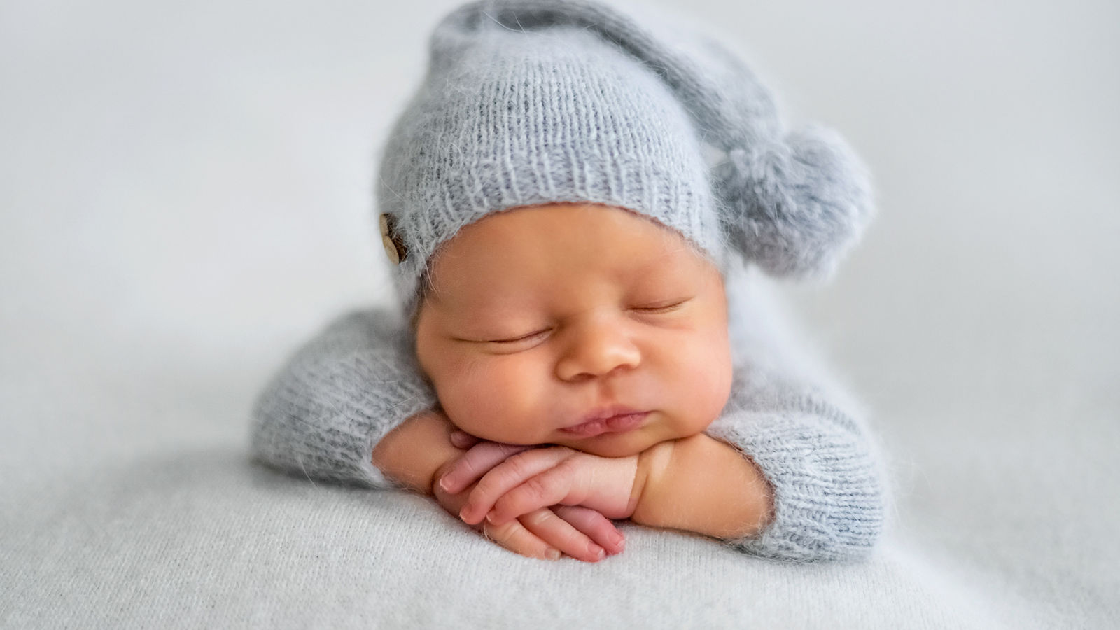 Sleeping newborn boy in the first days of life on white background