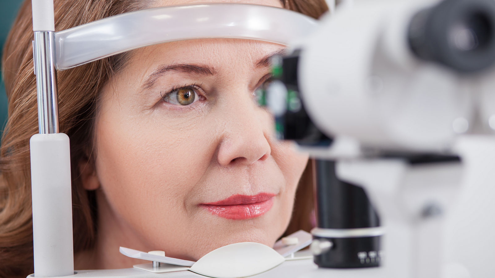 Cheerful lady having eye examination in oculist office