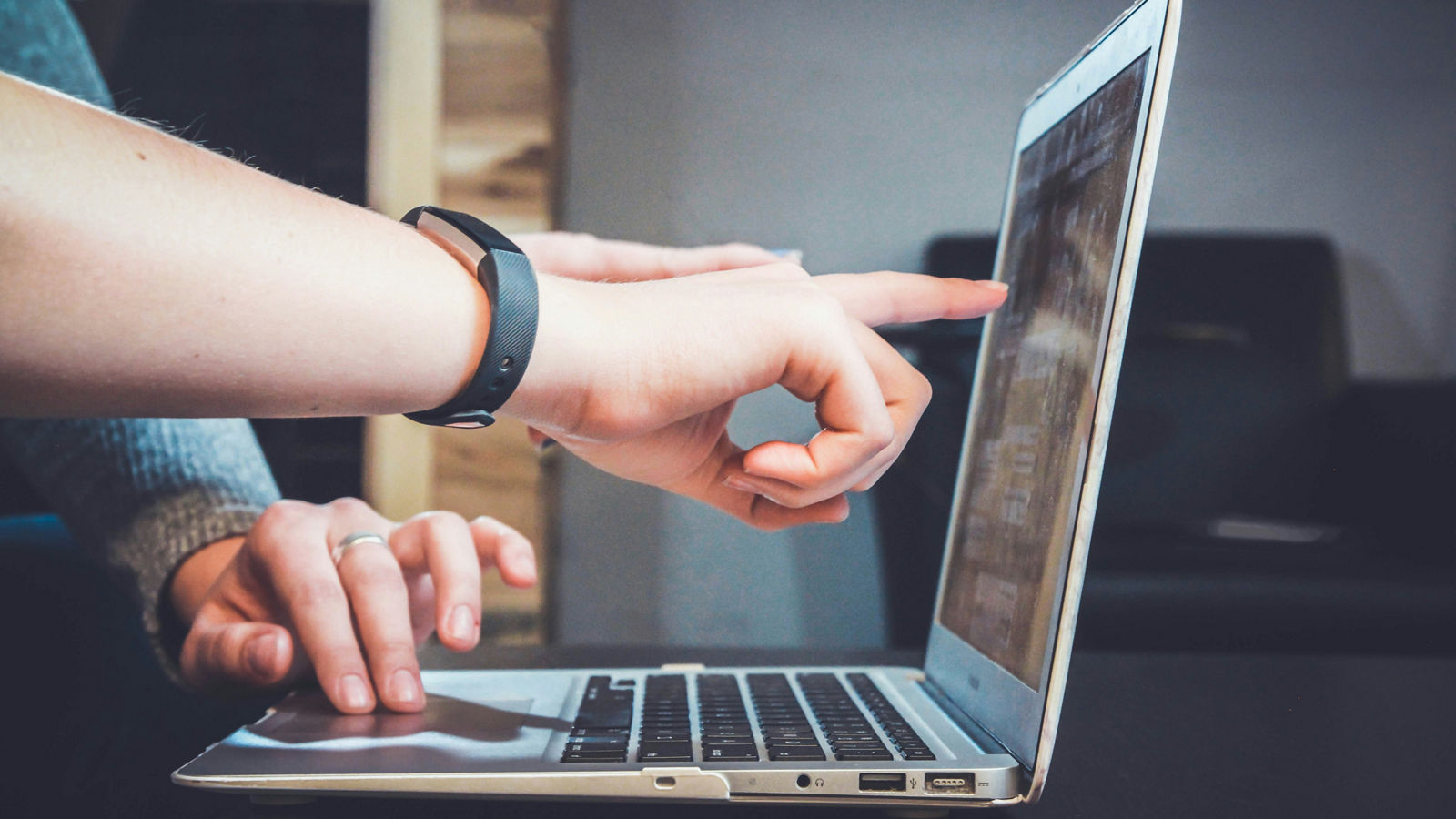 Hände zeigen auf Laptop Screen