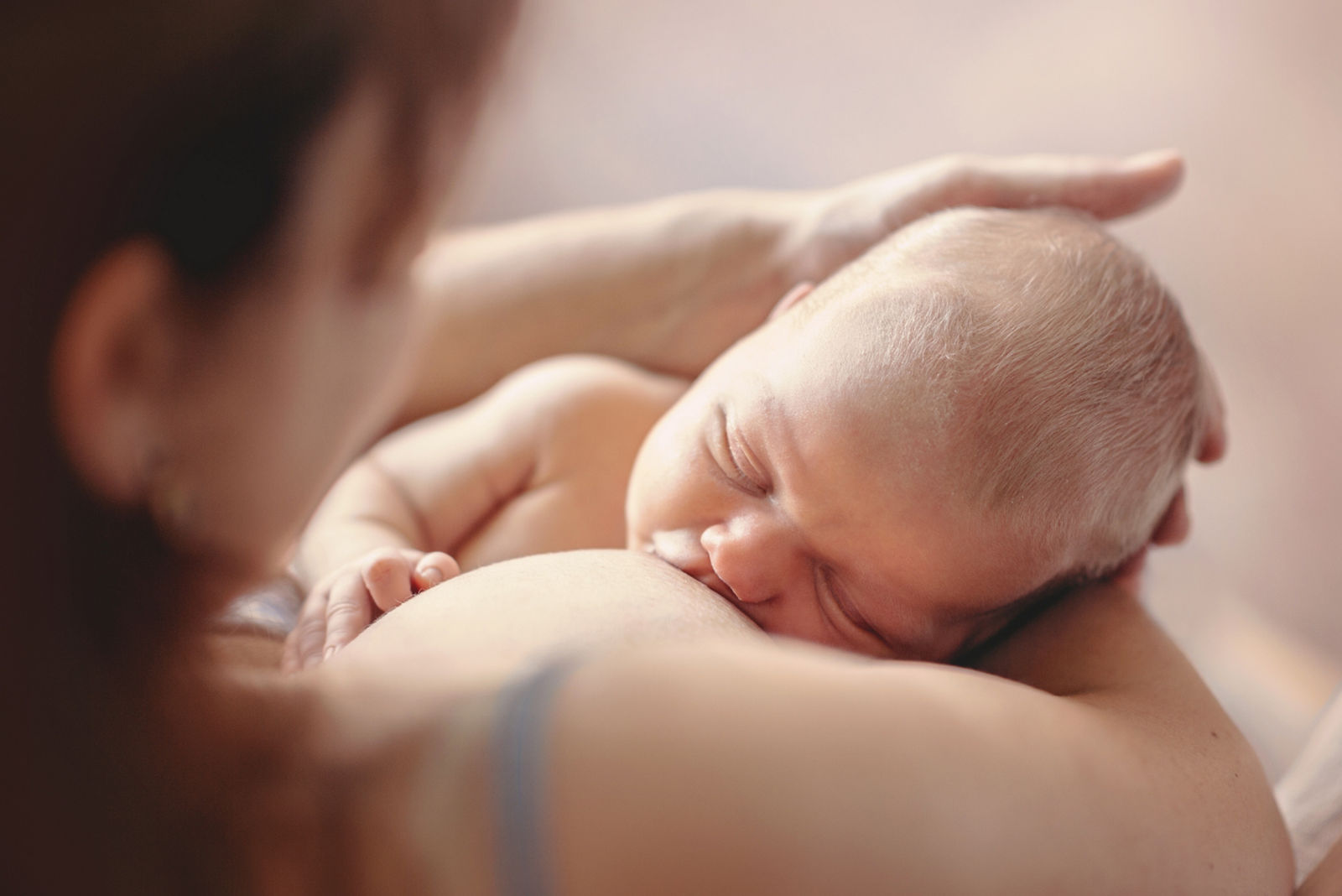 Mother breastfeeding her newborn child. Mom nursing baby.