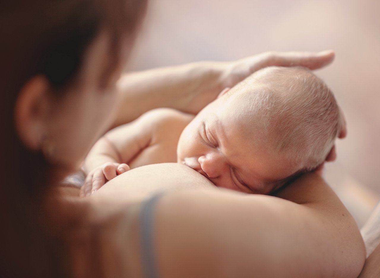 Mother breastfeeding her newborn child. Mom nursing baby.