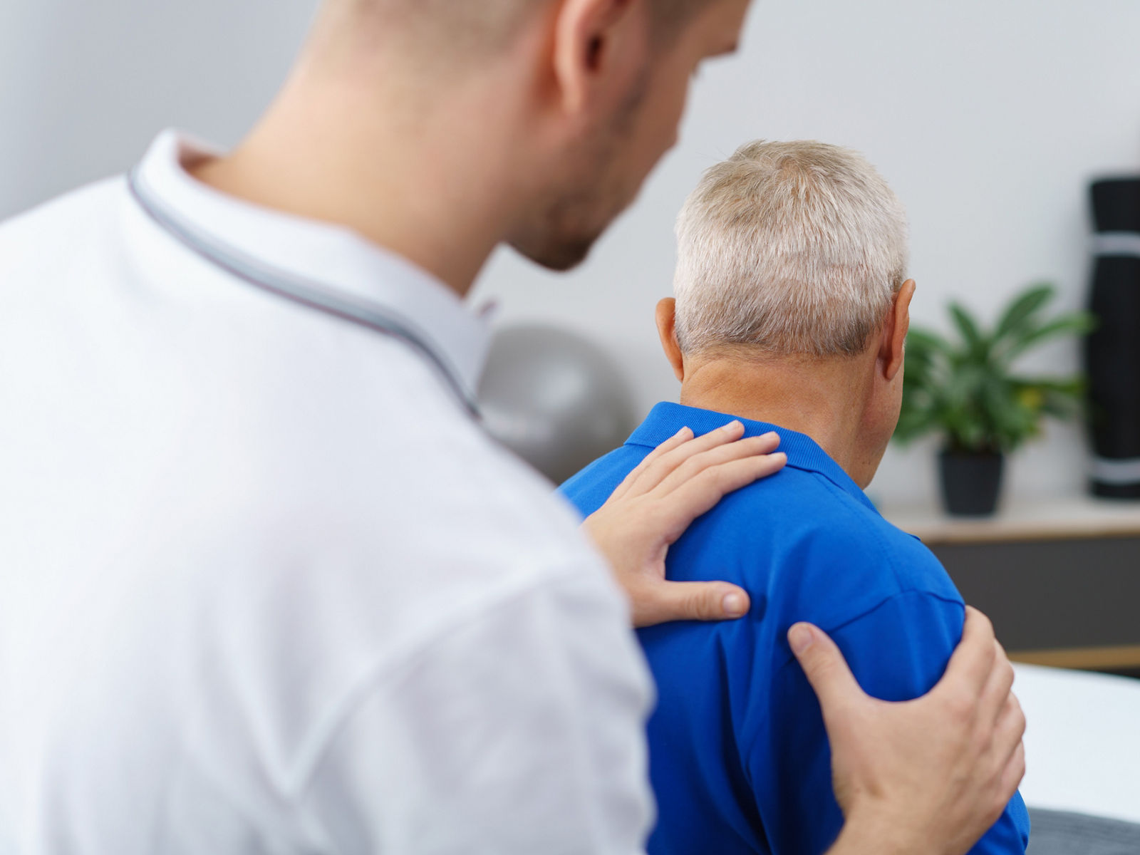 therapeut untersucht die schulter eines patienten