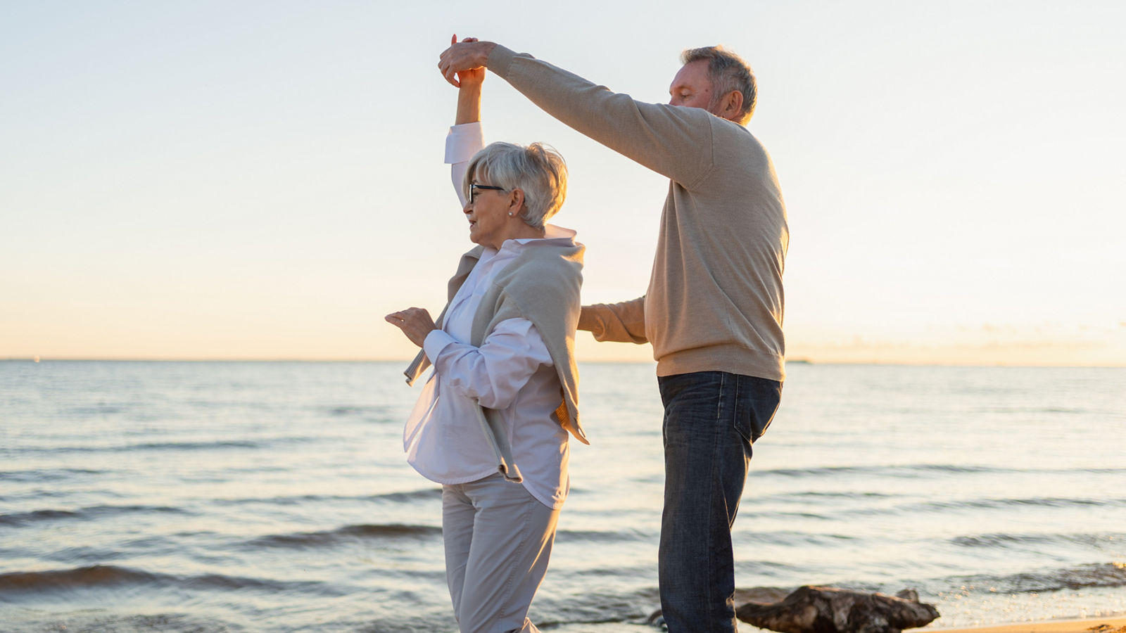 Älteres Ehepaar tanzt am Strand