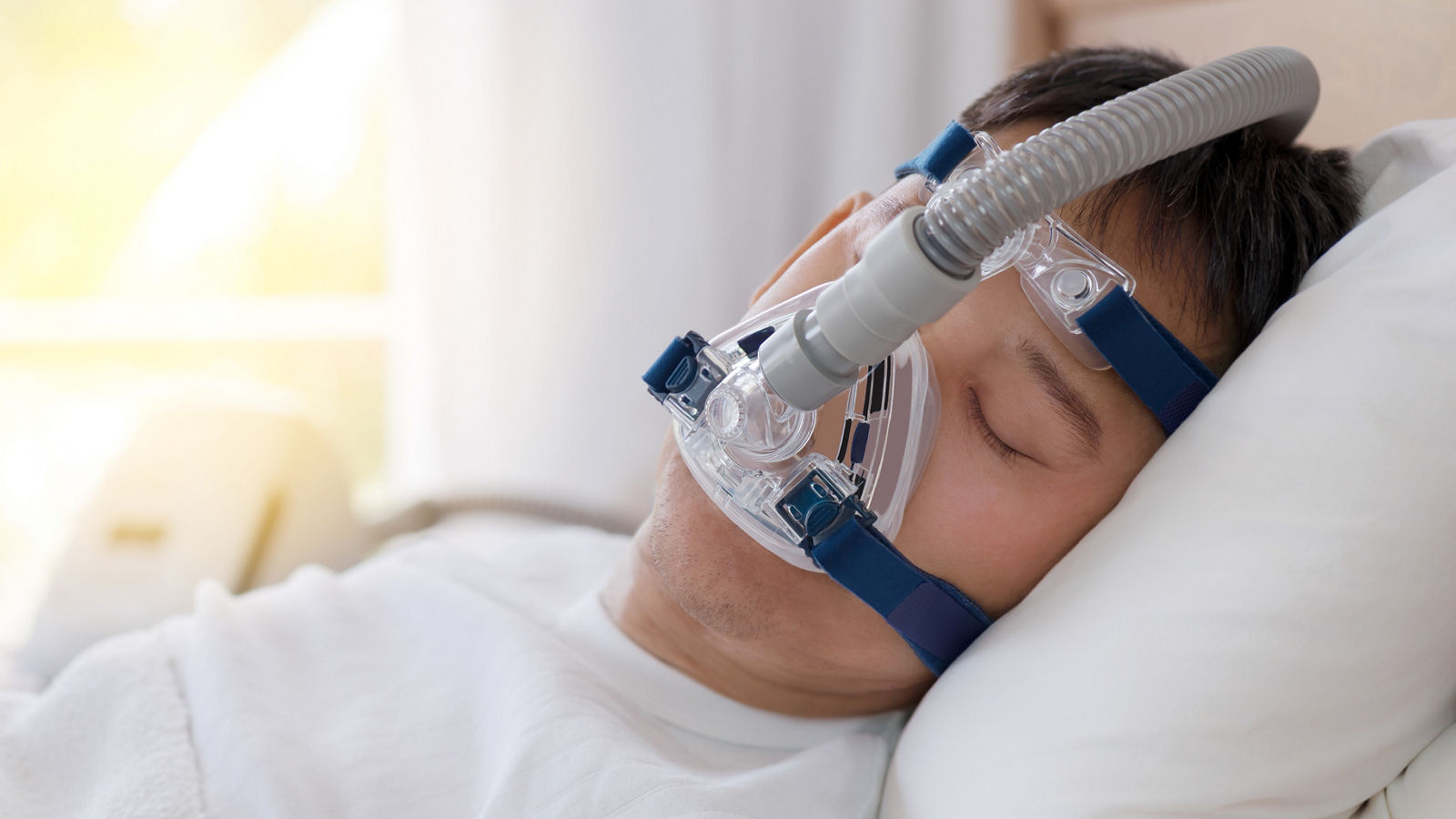 Sleep apnea therapy, Man sleeping in bed wearing CPAP mask.
Healthy senior man sleeping deeply, happy on his back without snoring

