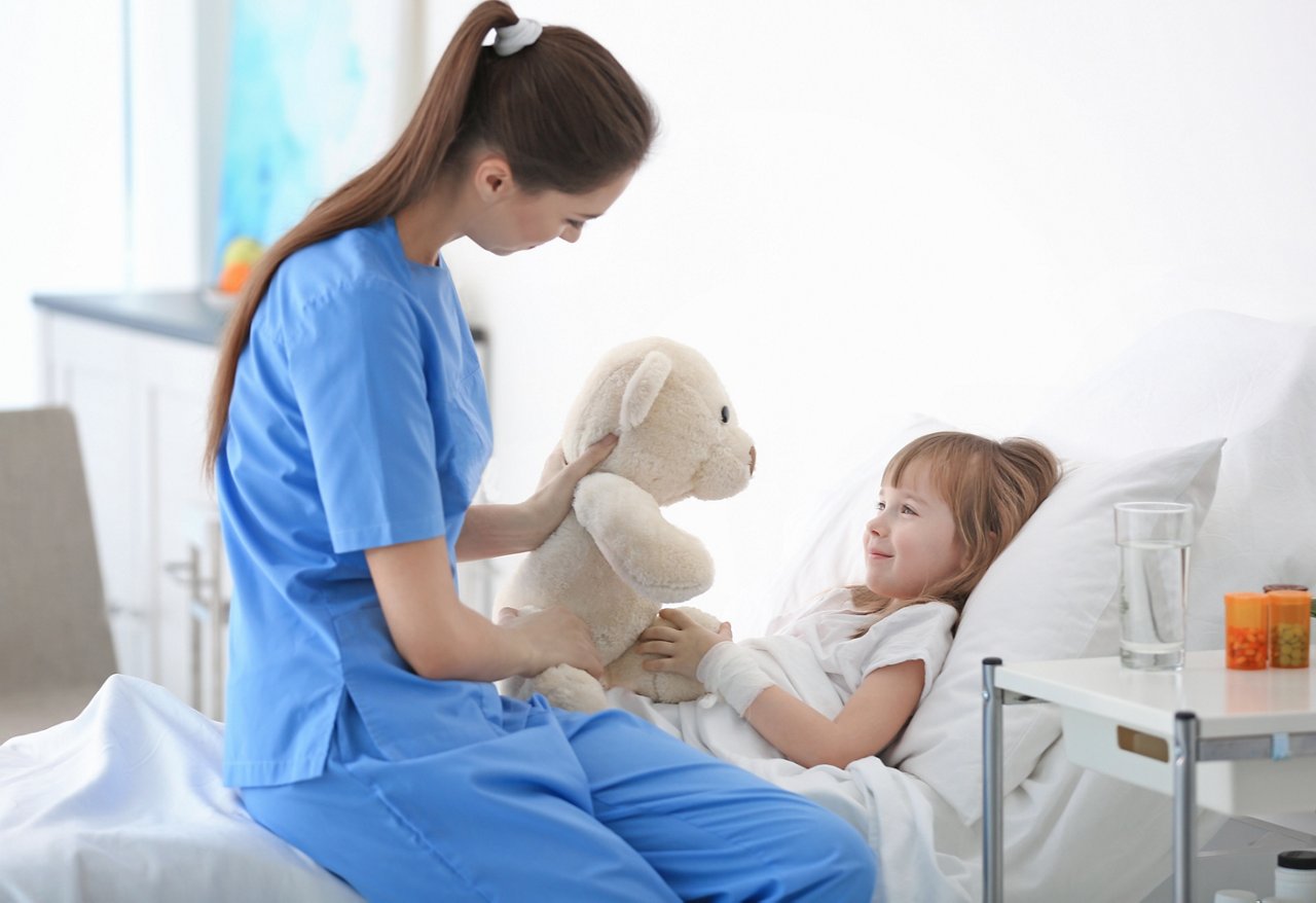 Doctor visiting little girl in hospital room