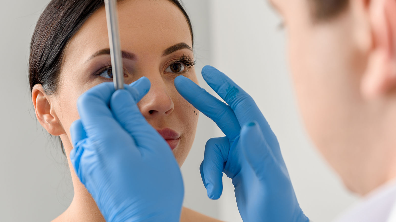 Physician examining face of serene female