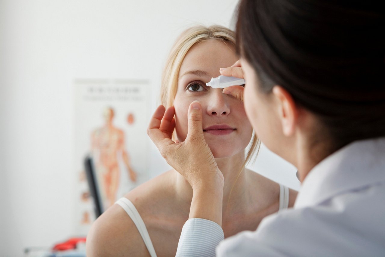 junge Frau bekommt Augentropfen