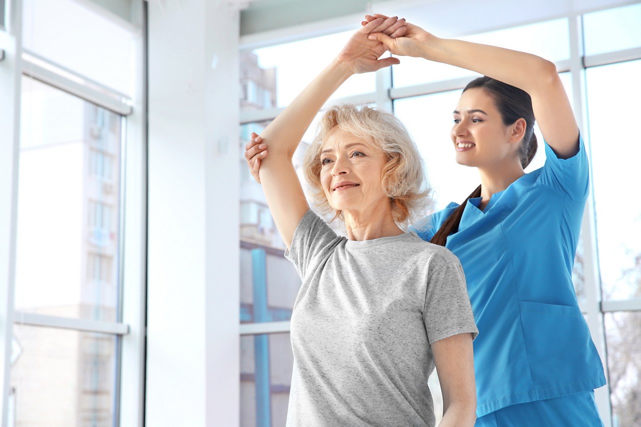 Physiotherapist working with elderly patient in clinic