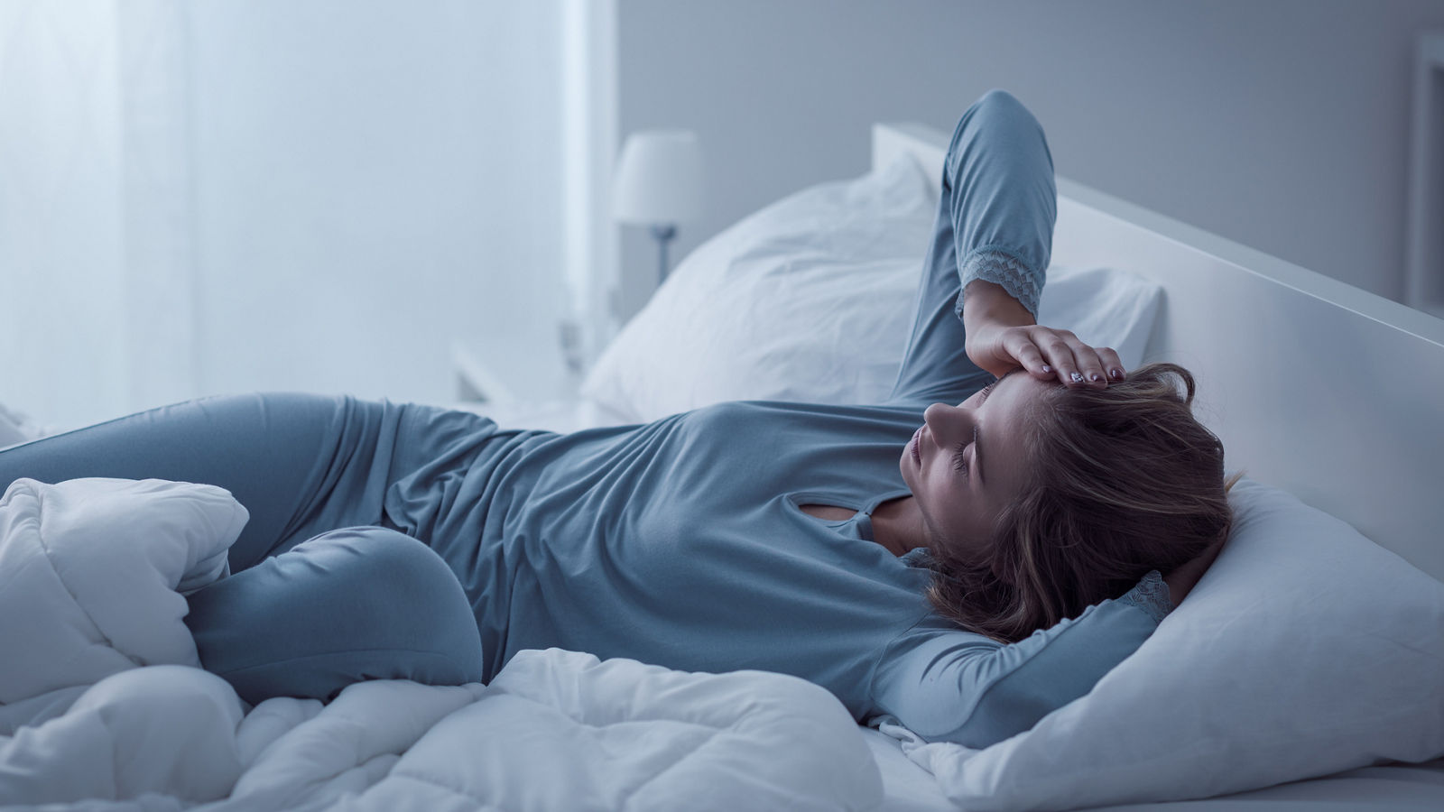 Depressed woman awake in the night, she is exhausted and suffering from insomnia