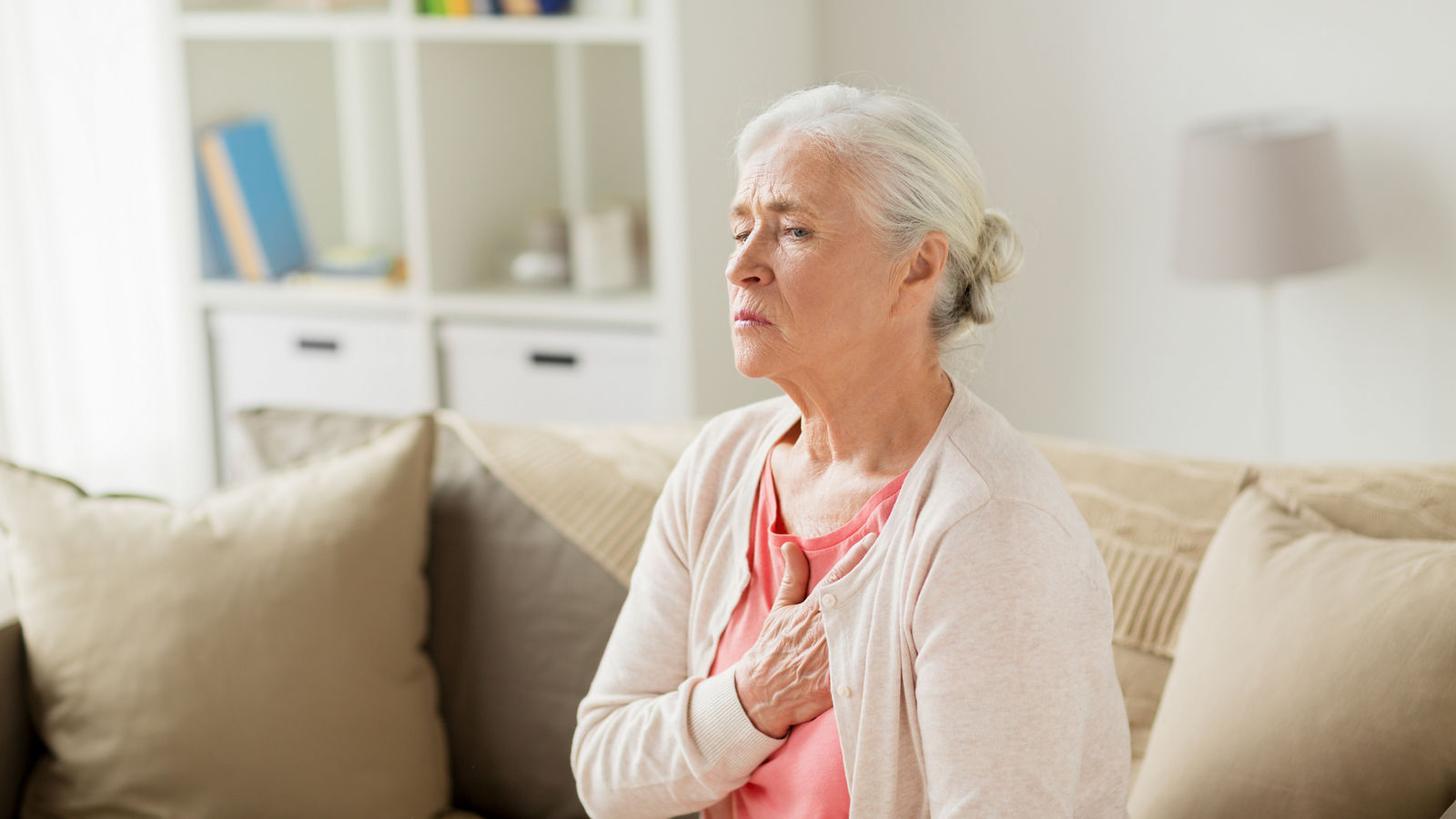 senior woman suffering from heartache at home