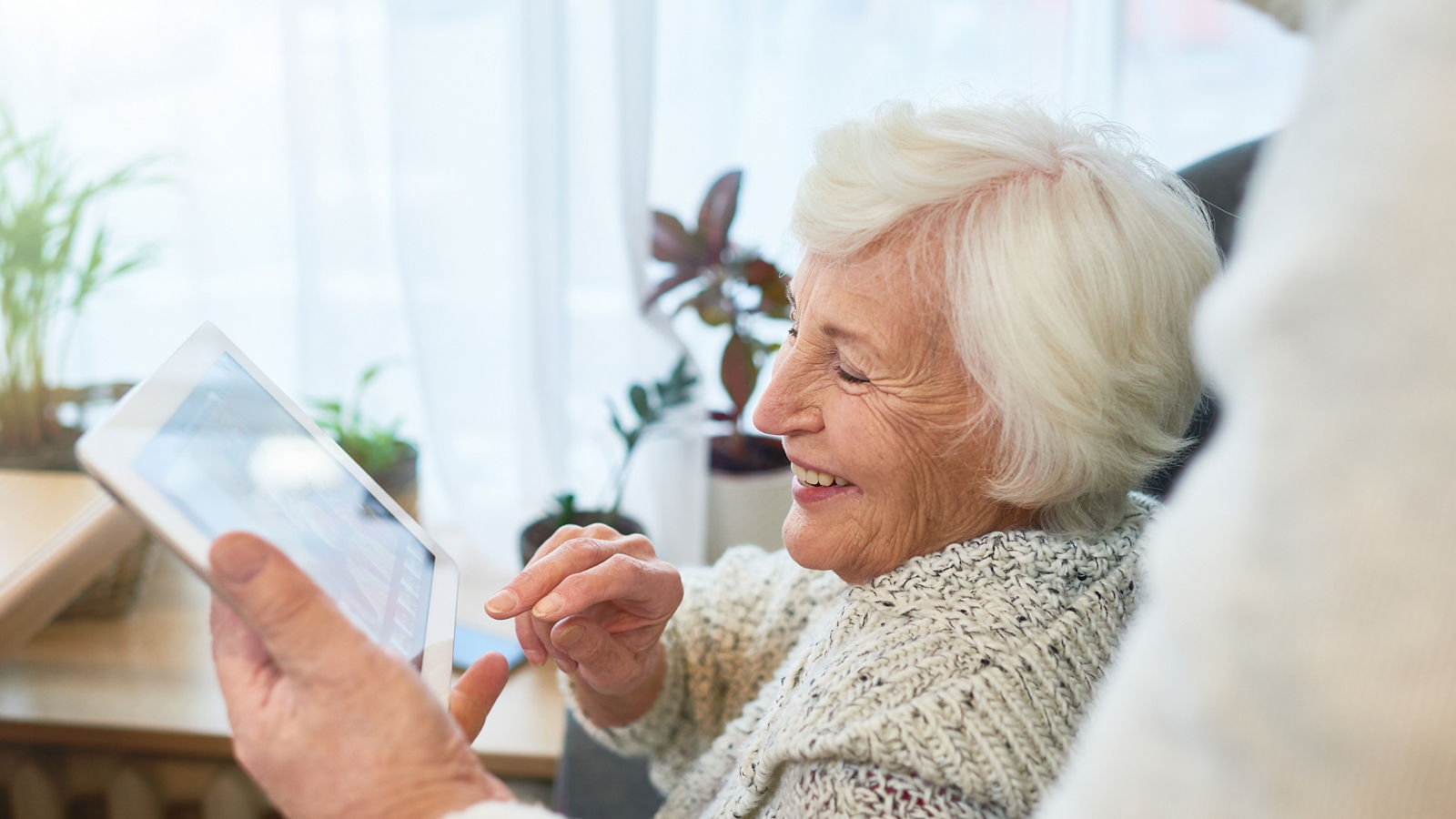 Laughing Elderly Lady Using Tablet