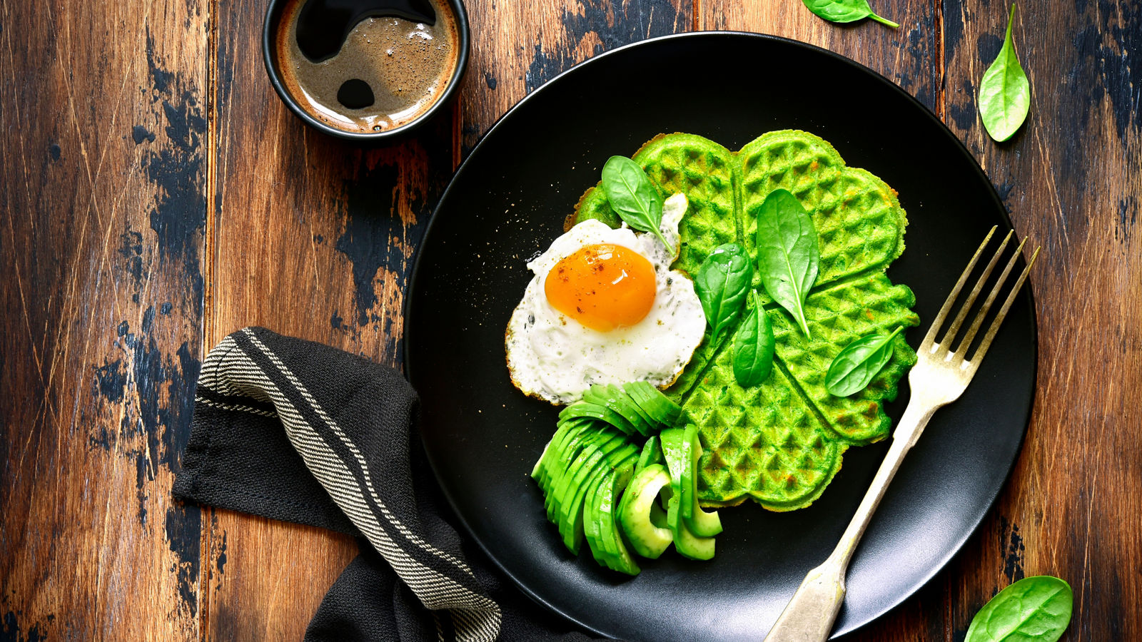 Spinach cheese waffles with fried egg and avocado.Top view.