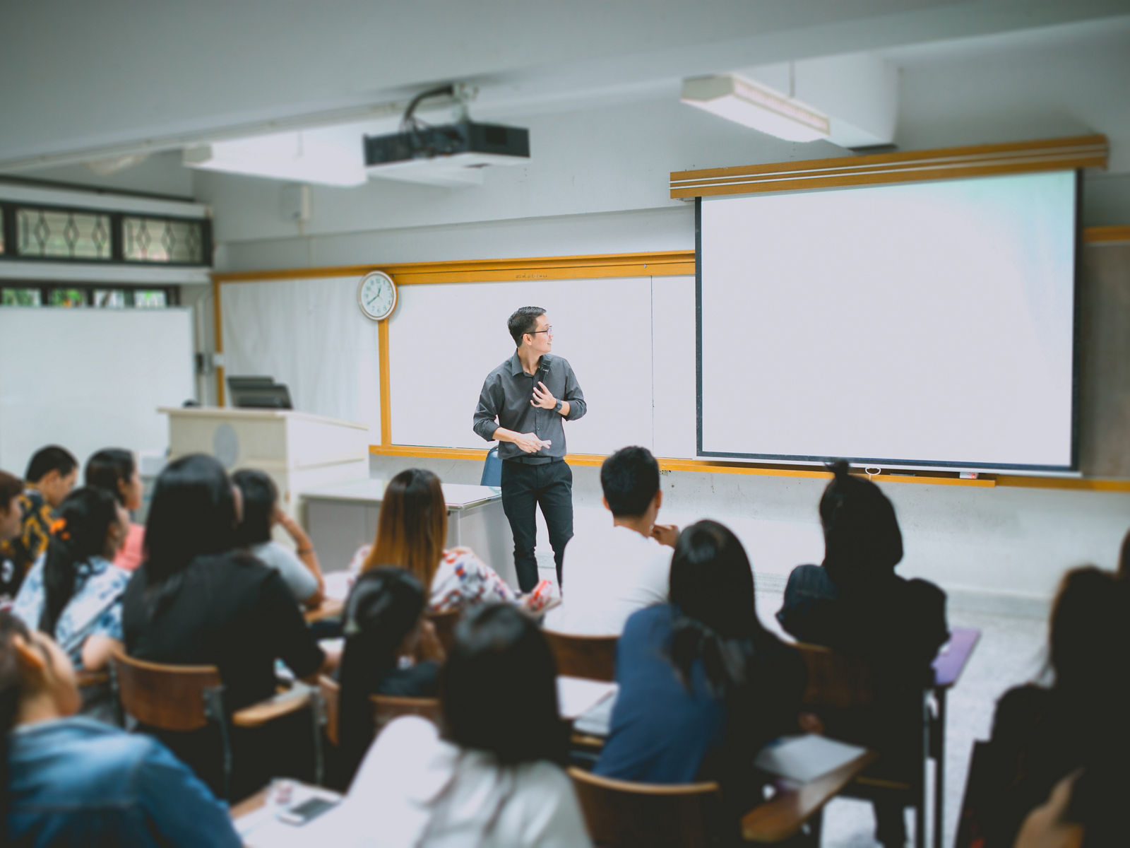 Teacher teaching studen in classroom at university.