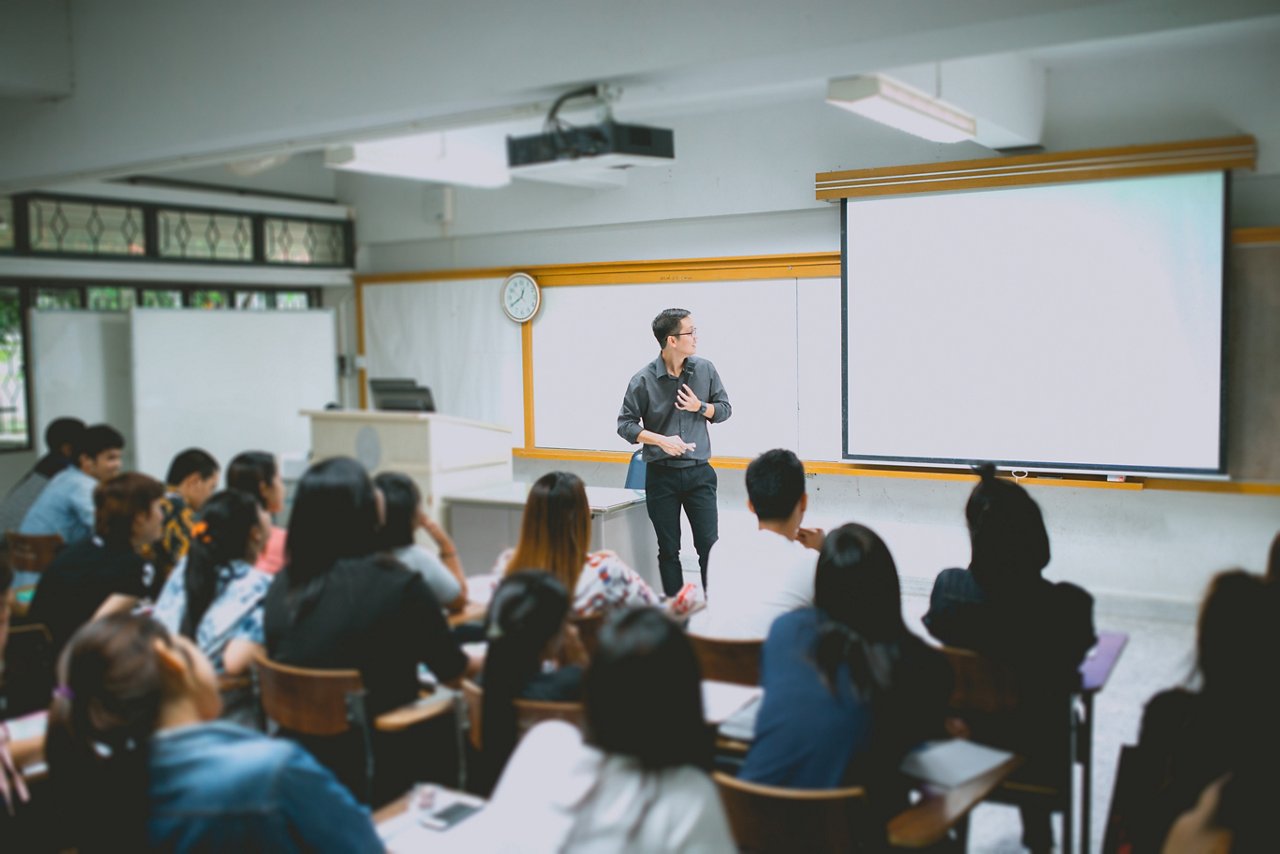 Teacher teaching studen in classroom at university.