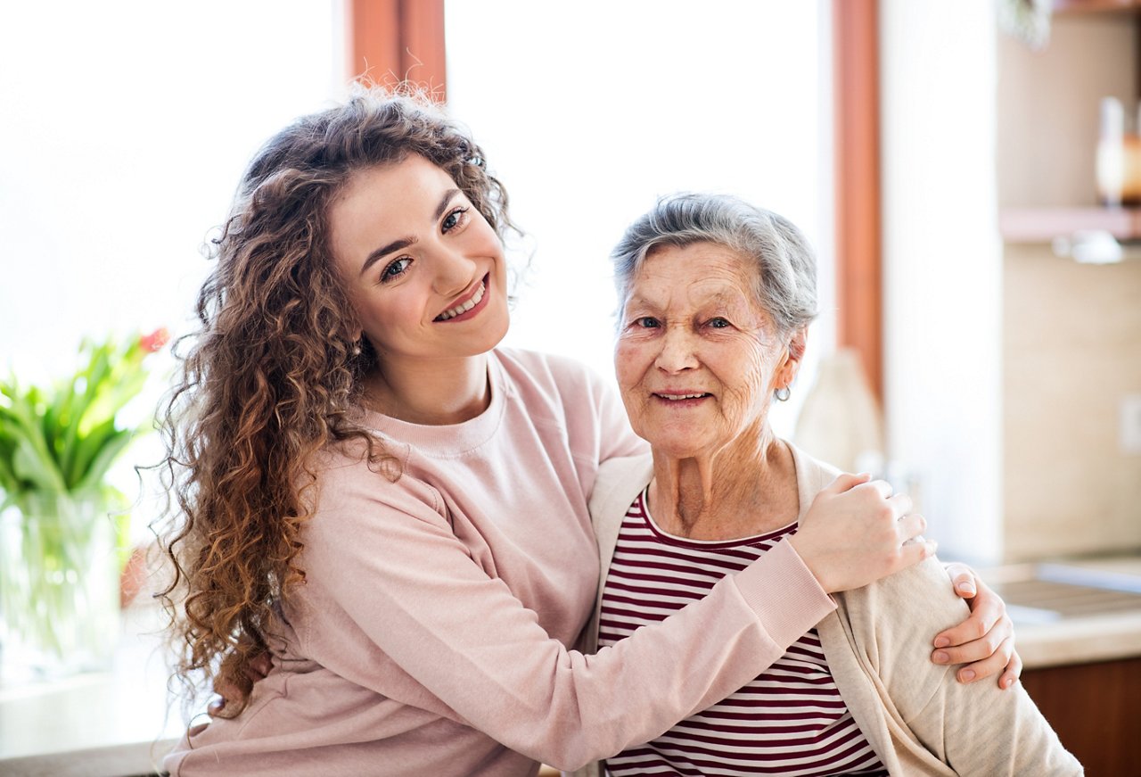 A teenage girl with grandmother at home. Family and generations concept.