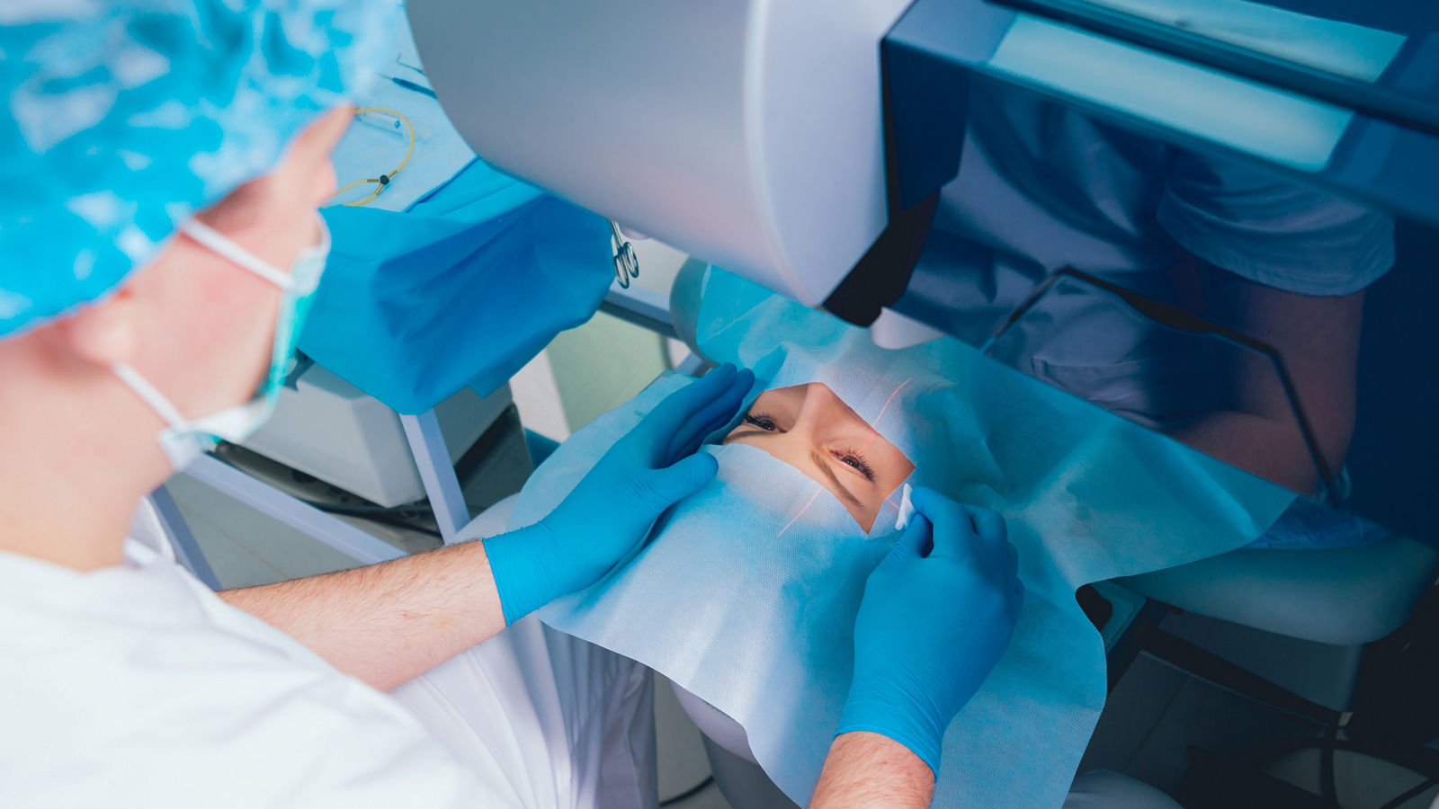 Laser vision correction. A patient and team of surgeons in the operating room during ophthalmic surgery. Eyelid speculum. Lasik treatment.