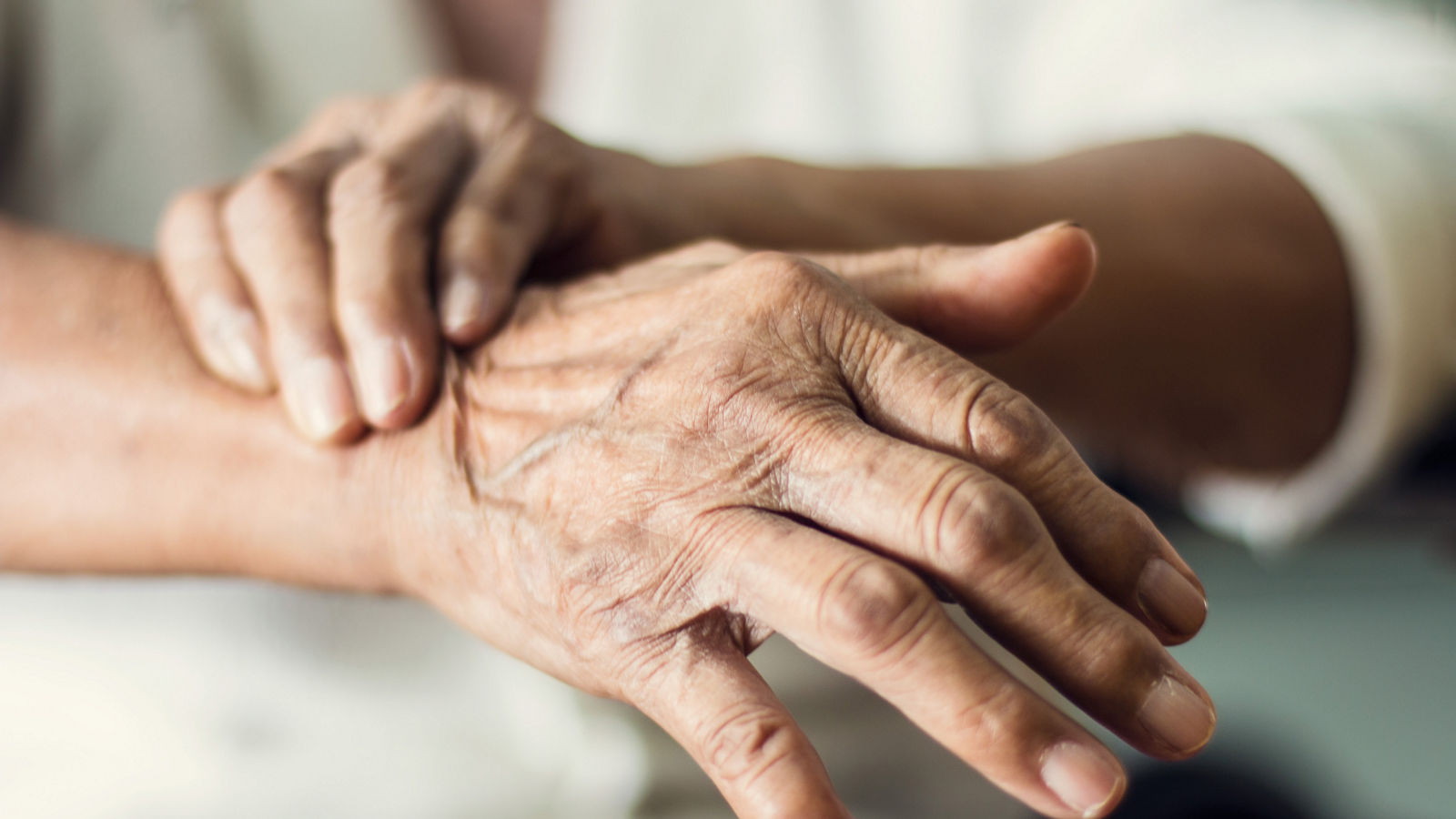 Close up hands of senior elderly woman patient suffering from pakinson's desease symptom. Mental health and elderly care concept